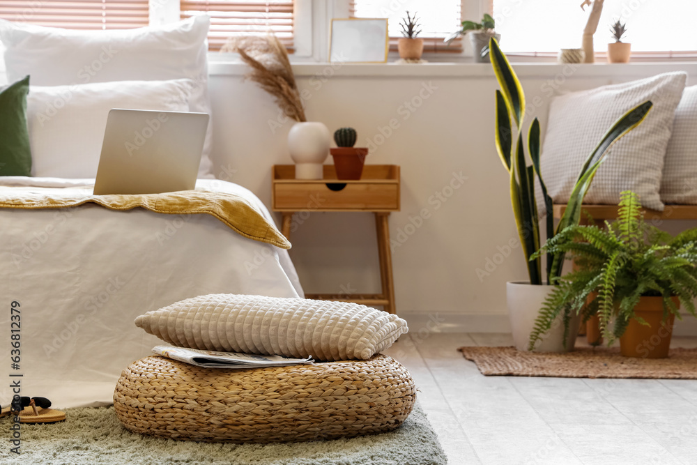 Interior of stylish bedroom with rattan pouf