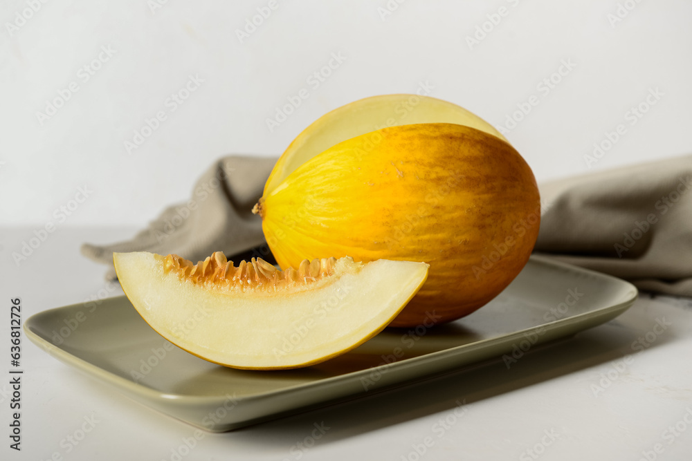 Plate with tasty ripe melon on table