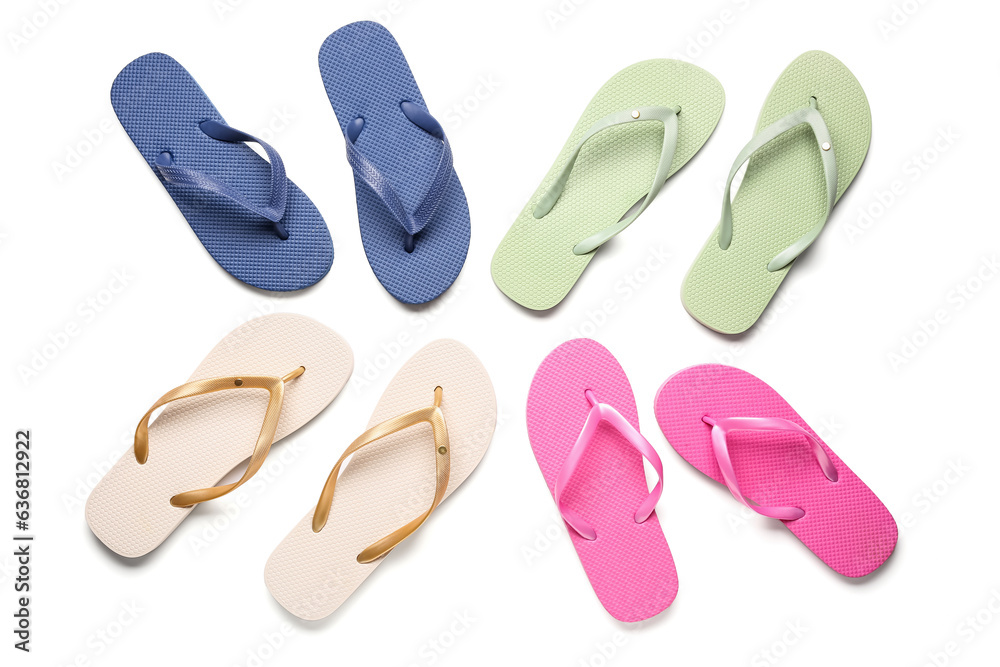 Colorful pairs of female flip flops on white background