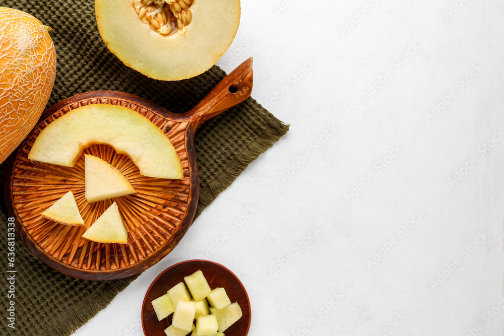 Wooden board and bowl with sweet cut melon on white background