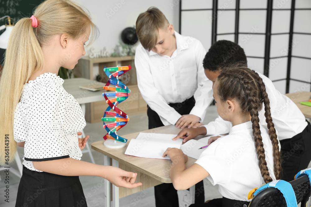 Little classmates writing at desk in classroom