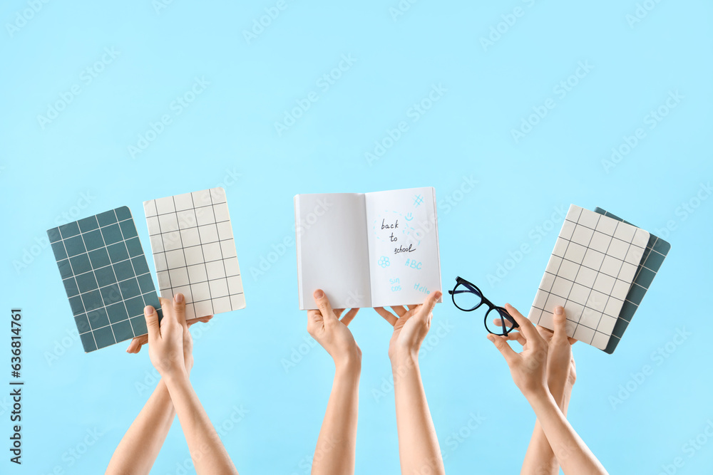 Female hands holding eyeglasses and notebooks with text BACK TO SCHOOL on blue background