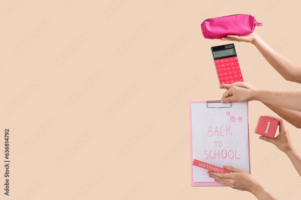 Female hands holding different stationery and notebook with text BACK TO SCHOOL on beige background