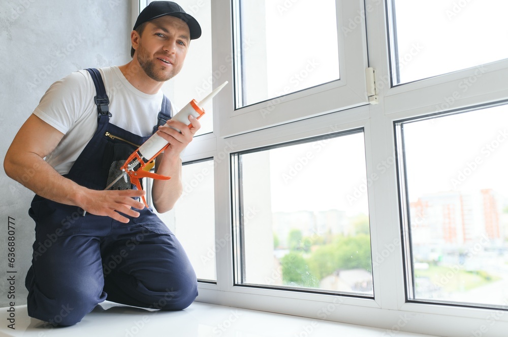 Man putting filling between window and wall in a new house