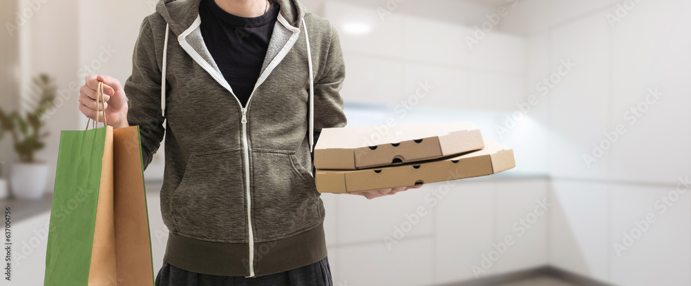 Paper pocket and food containers in hands of a smiling deliveryman. Quality service of a restaurant.