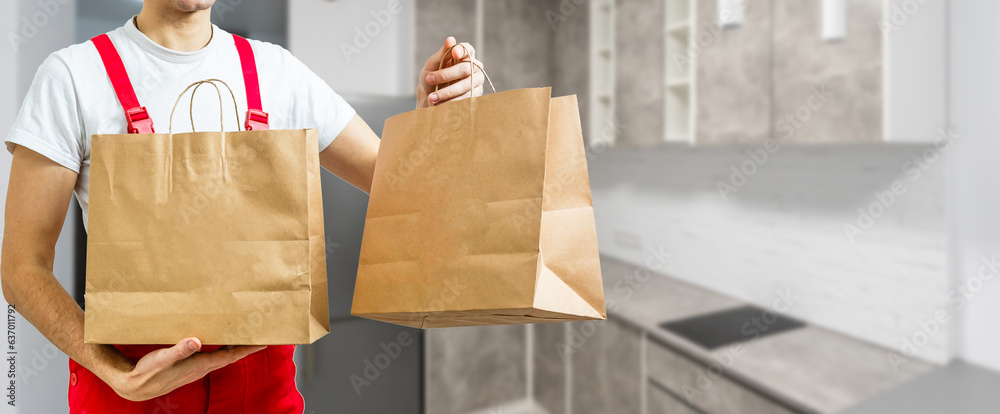 box with fast food being carried by delivery man in uniform for one of clients