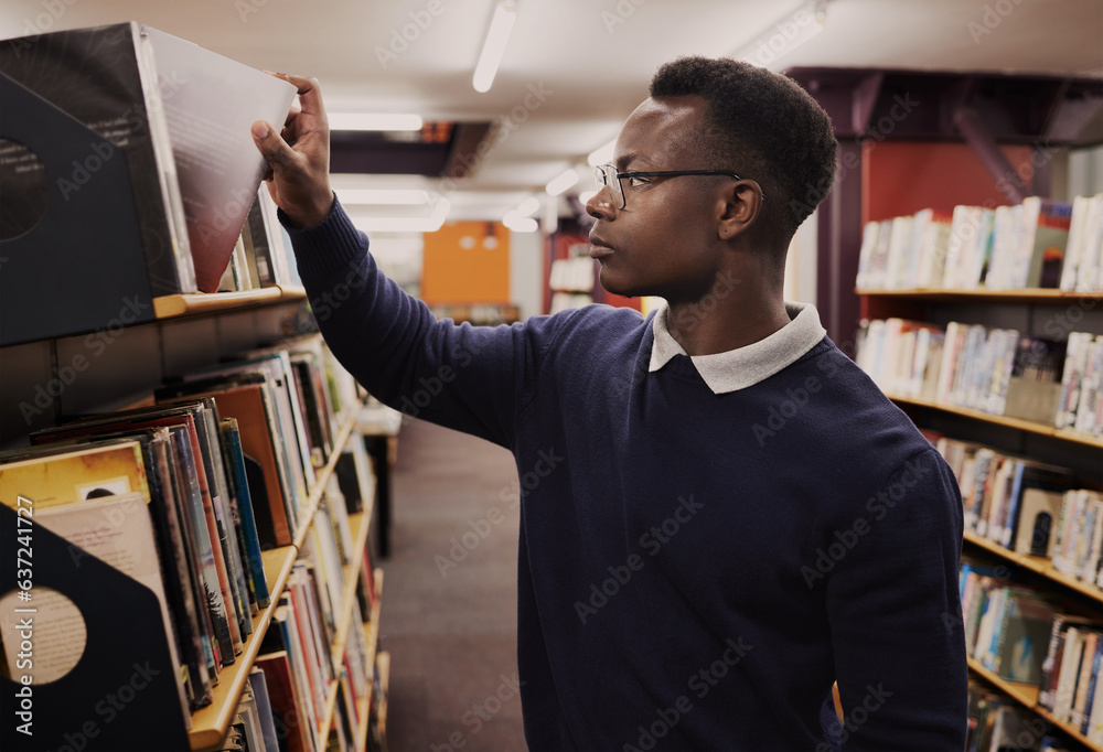 University, books and black man in a library reading and learning on campus for knowledge and educat