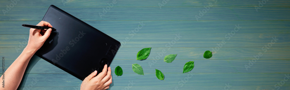 Graphic pen tablet with green leaves - flat lay