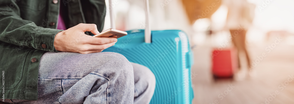 Man with smartphone sitting in airport.