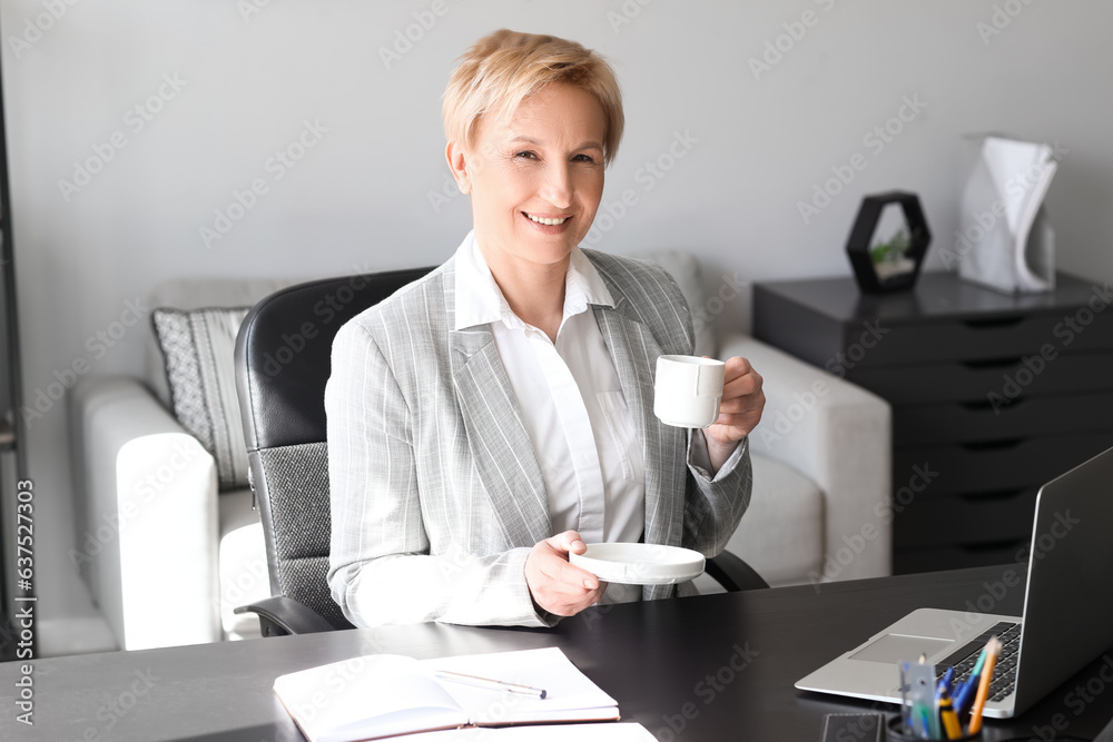 Mature businesswoman drinking  coffee in office