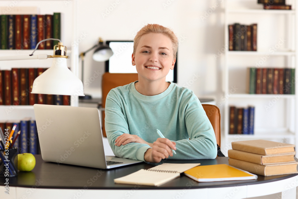 Female student studying at table in library