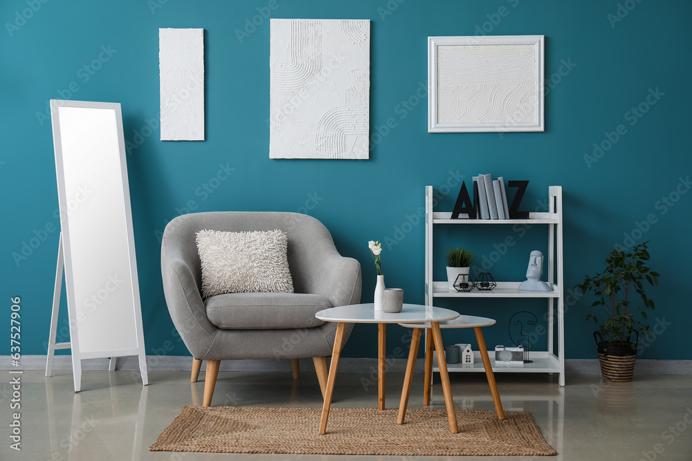 Interior of room with shelving unit and stylish holder for books near blue wall