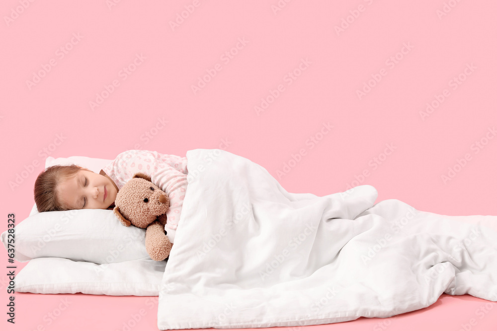 Little girl with toy and soft blanket sleeping on pink background