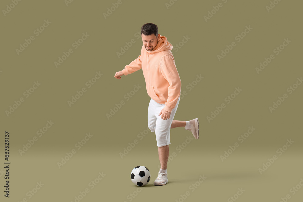 Man playing with soccer ball on color background