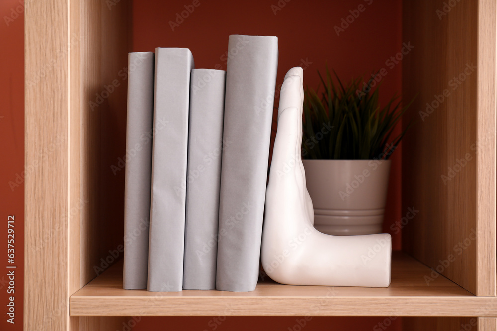 Brown shelving unit with stylish holder for books and houseplant