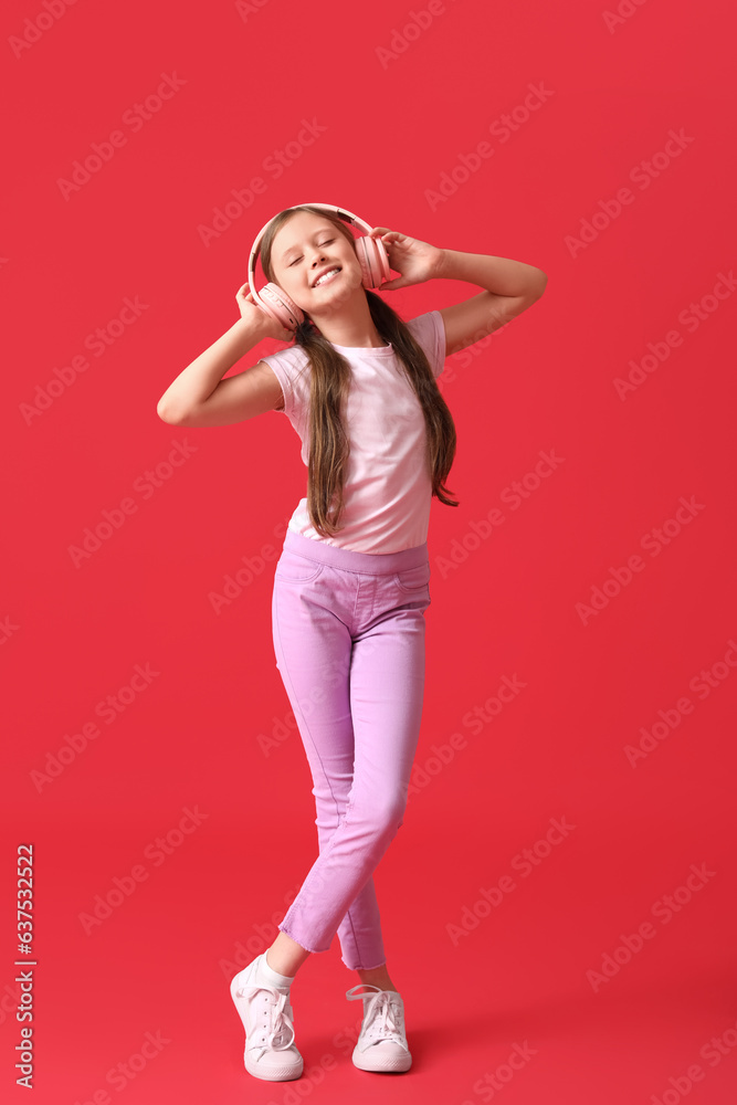 Little girl in headphones on red background