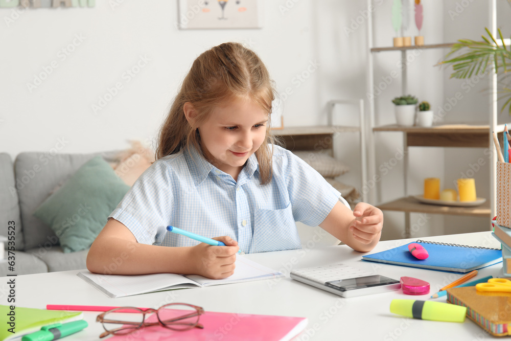 Cute little girl with calculator doing Math at home