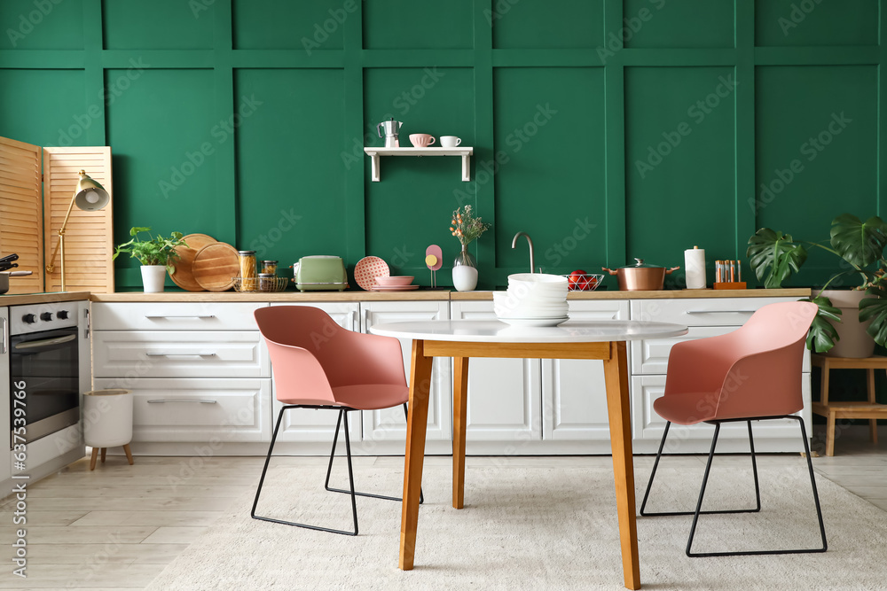 Interior of modern kitchen with white counters and dining table