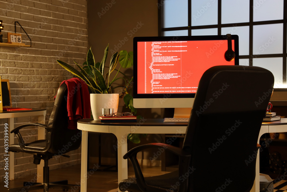 Programmers workplace with computer in dark office