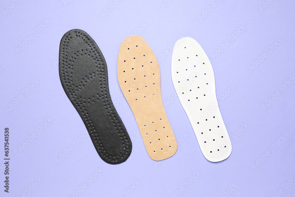 Different orthopedic insoles on lilac background