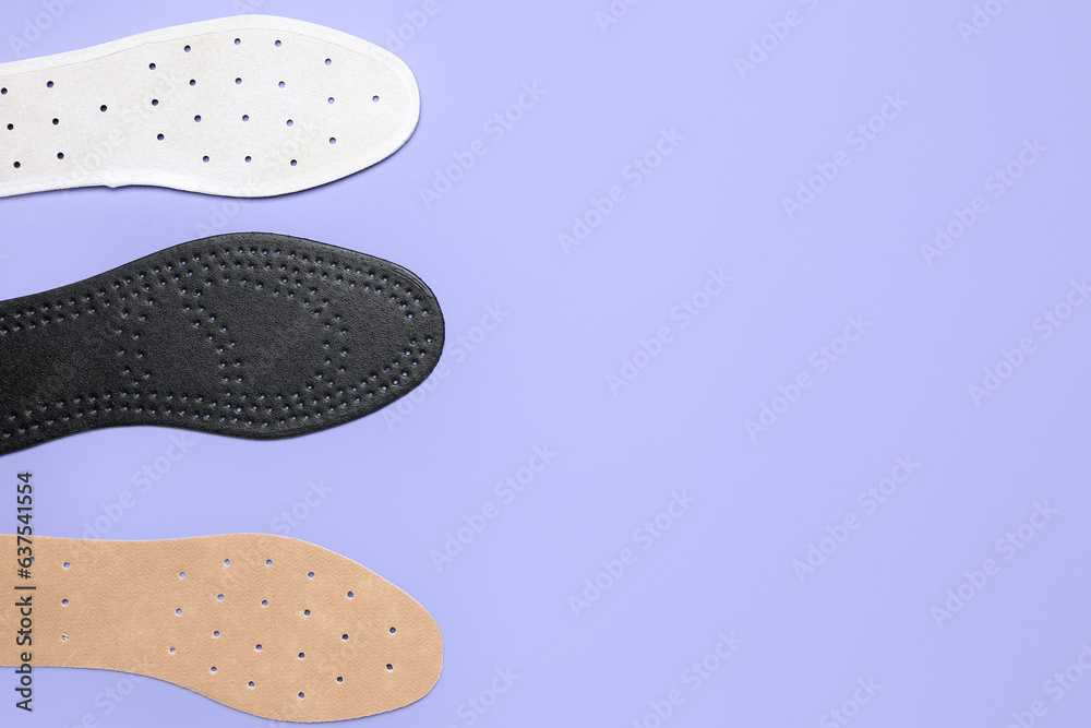 Different orthopedic insoles on lilac background