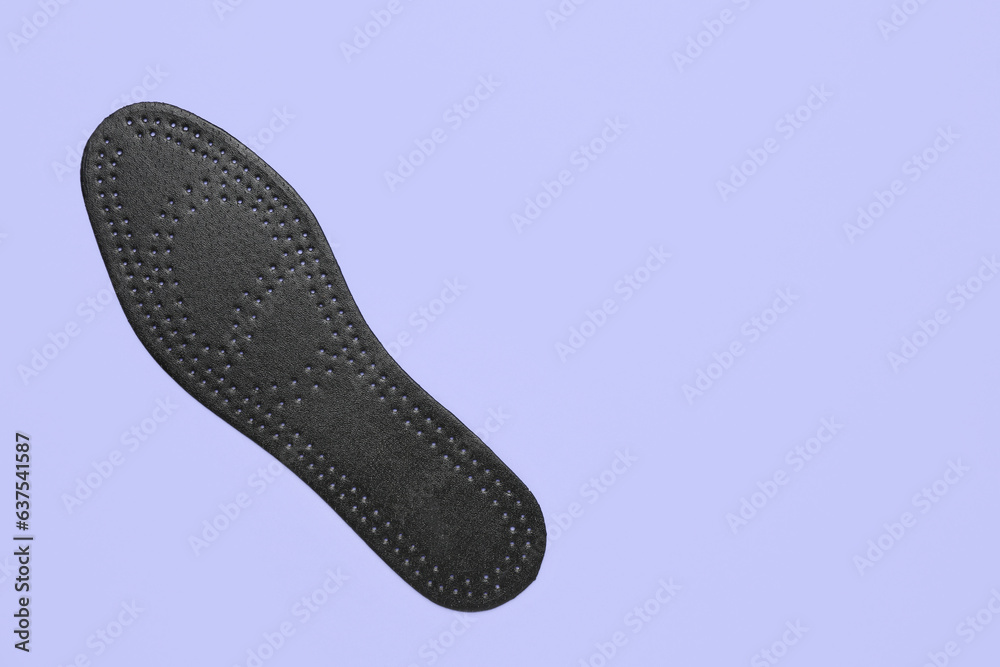 Black orthopedic insole on lilac background