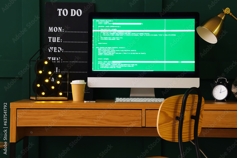 Programmers workplace with computer monitor and cup of coffee in office