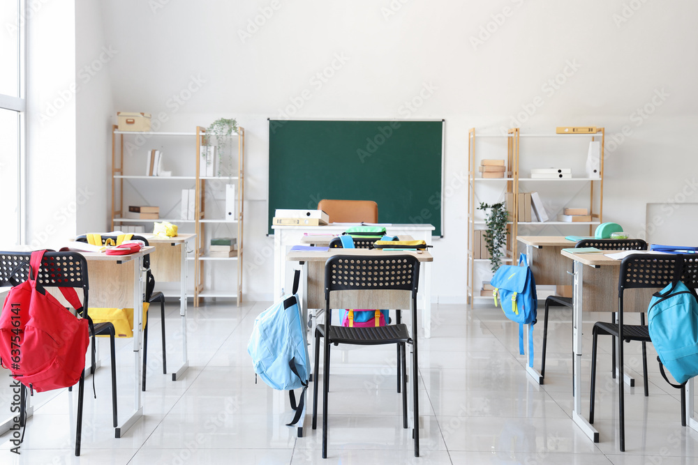 Interior of modern classroom with desks and chairs at school