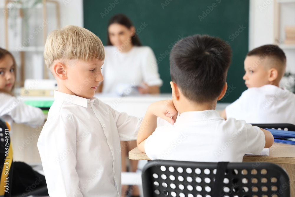 Little school boys in classroom during lesson