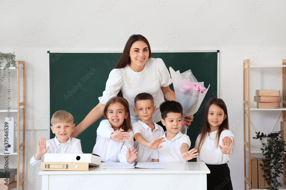 Female teacher with little school children in classroom