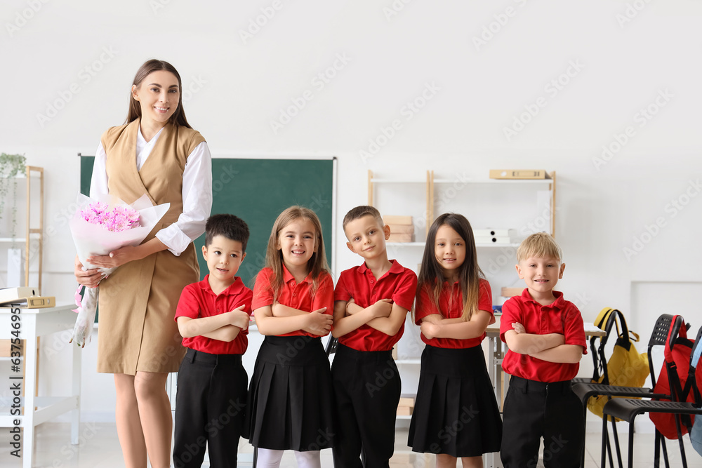 Female teacher with little school children in classroom