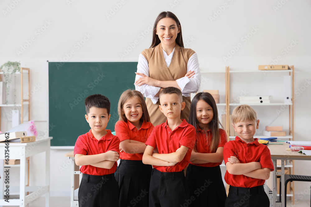 Female teacher with little school children in classroom