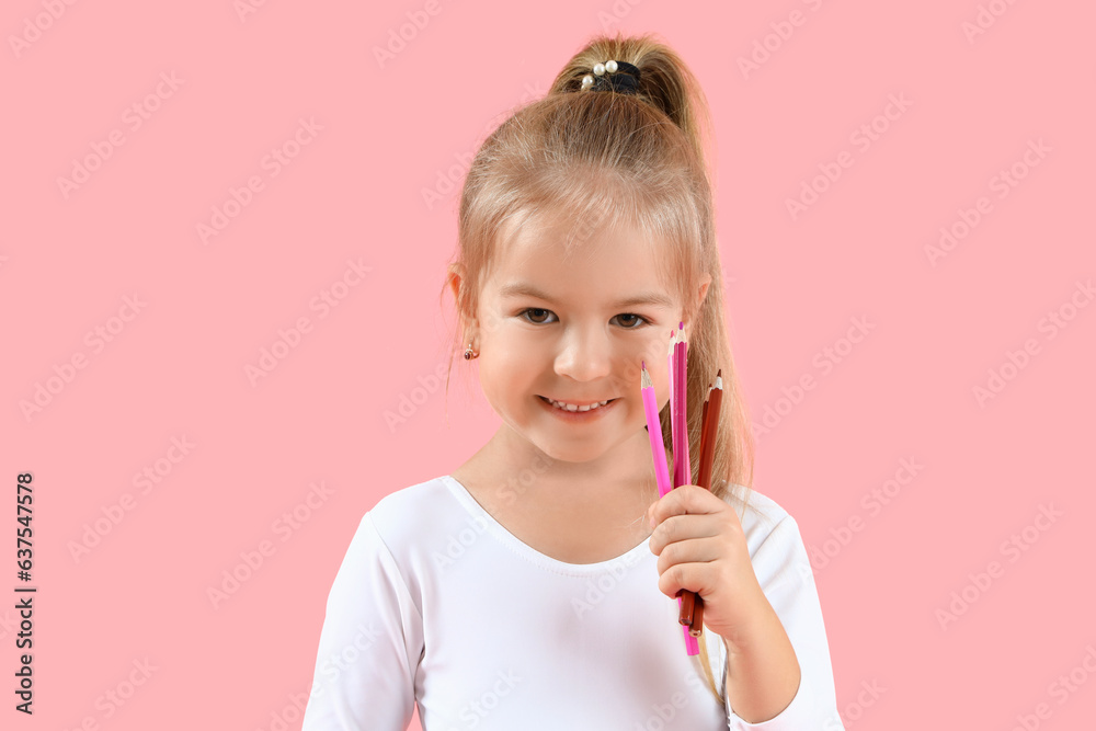 Cute little girl with pencils on pink background