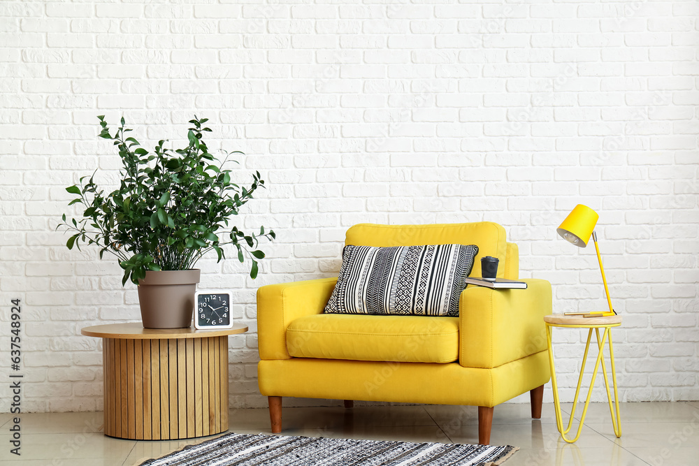 Interior of living room with yellow armchair, desk lamp and houseplant