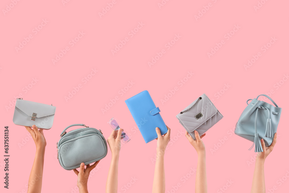 Female hands holding stylish womens bags and sunglasses on pink background