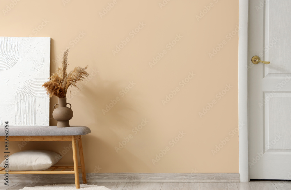 Interior of stylish room with soft bench near beige wall