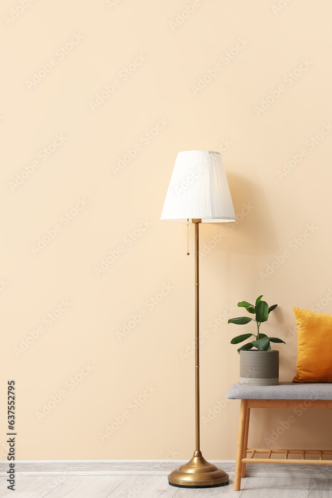 Interior of stylish room with soft bench near beige wall