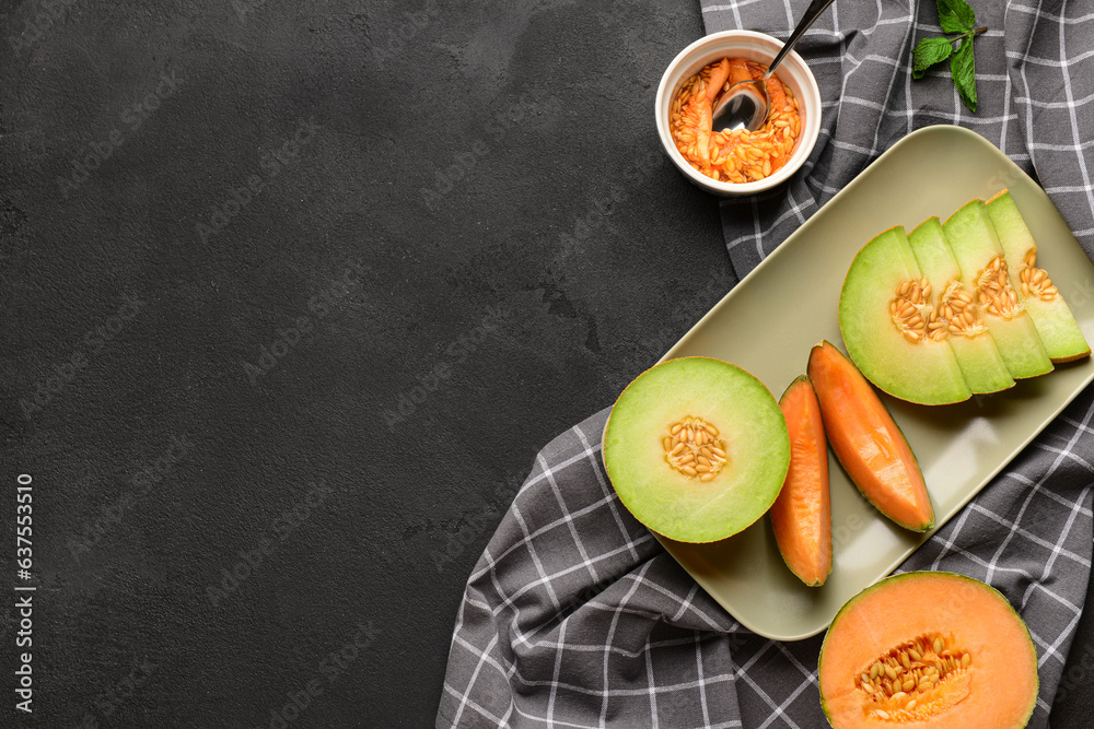 Plate with ripe cut melons on black background