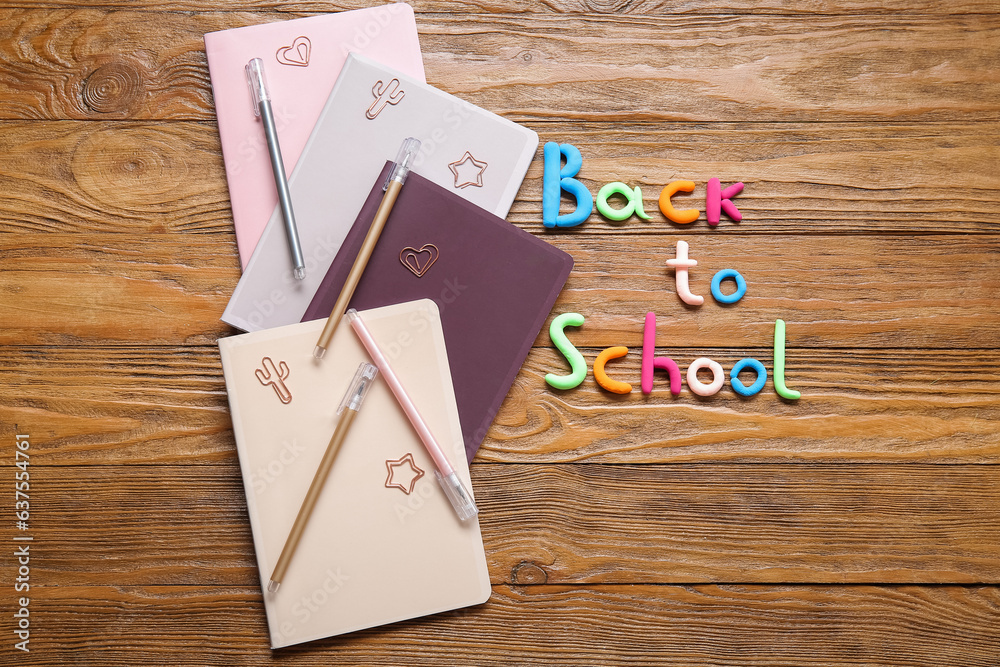 Text BACK TO SCHOOL and stationery on wooden background