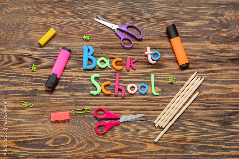 Text BACK TO SCHOOL and stationery on wooden background