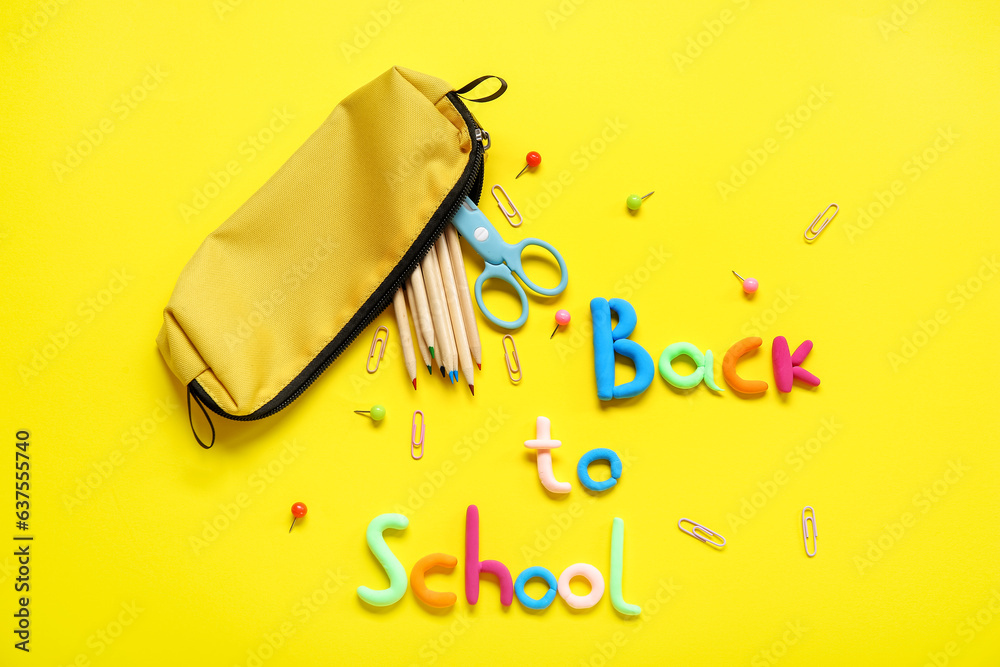 Text BACK TO SCHOOL and stationery on yellow background