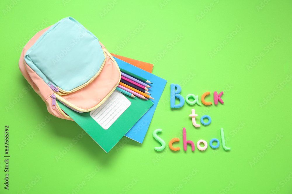 Text BACK TO SCHOOL, backpack and stationery on green background