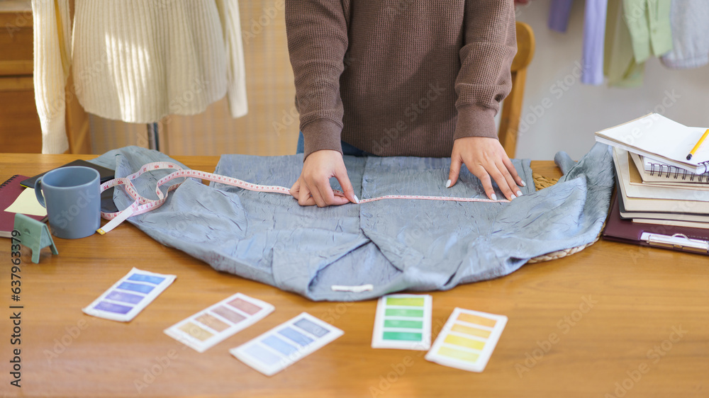 Fashion design concept, Fashion designer measuring size of shirt to checkup before sending customer