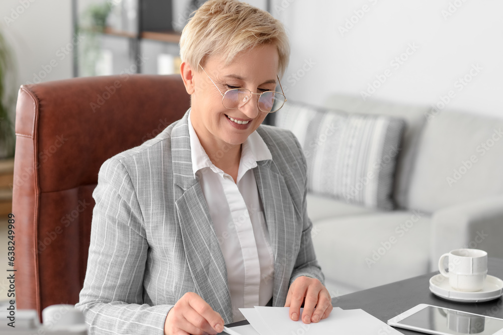 Mature businesswoman working with papers in office