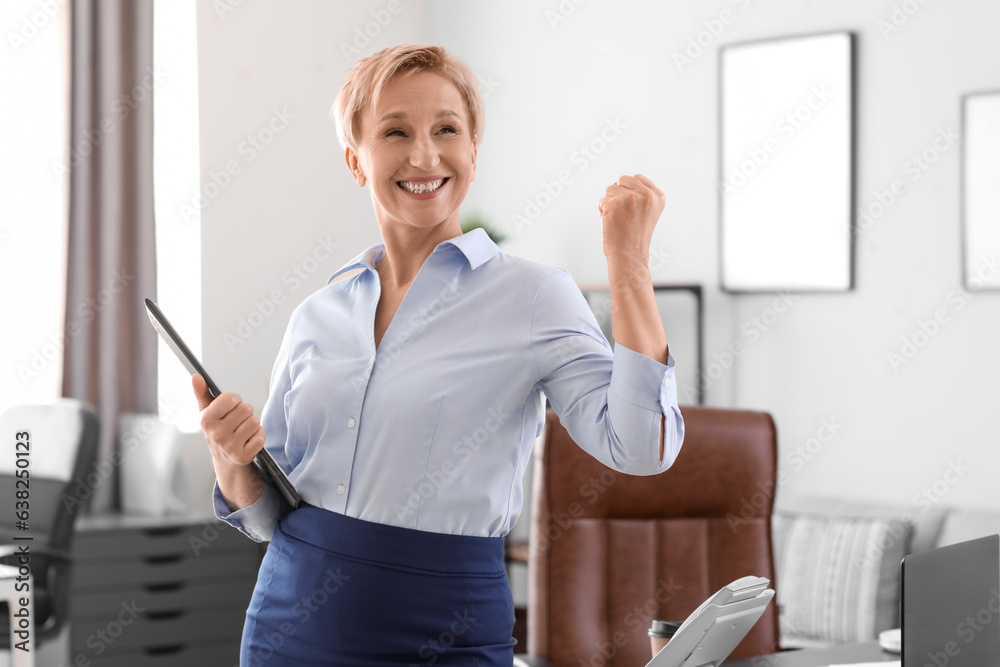 Happy mature businesswoman in office