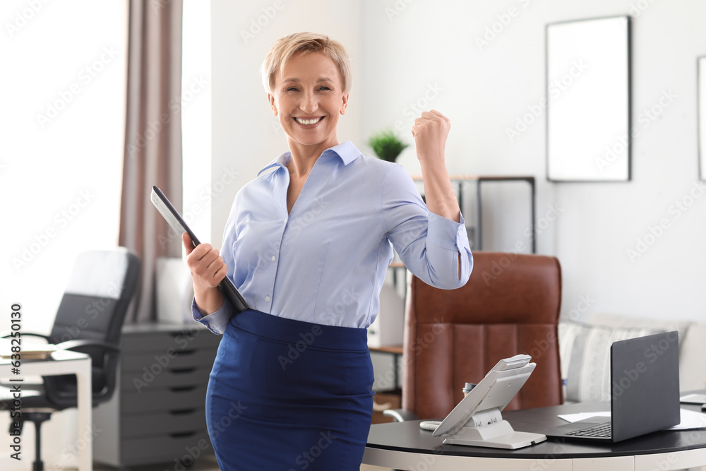 Happy mature businesswoman in office