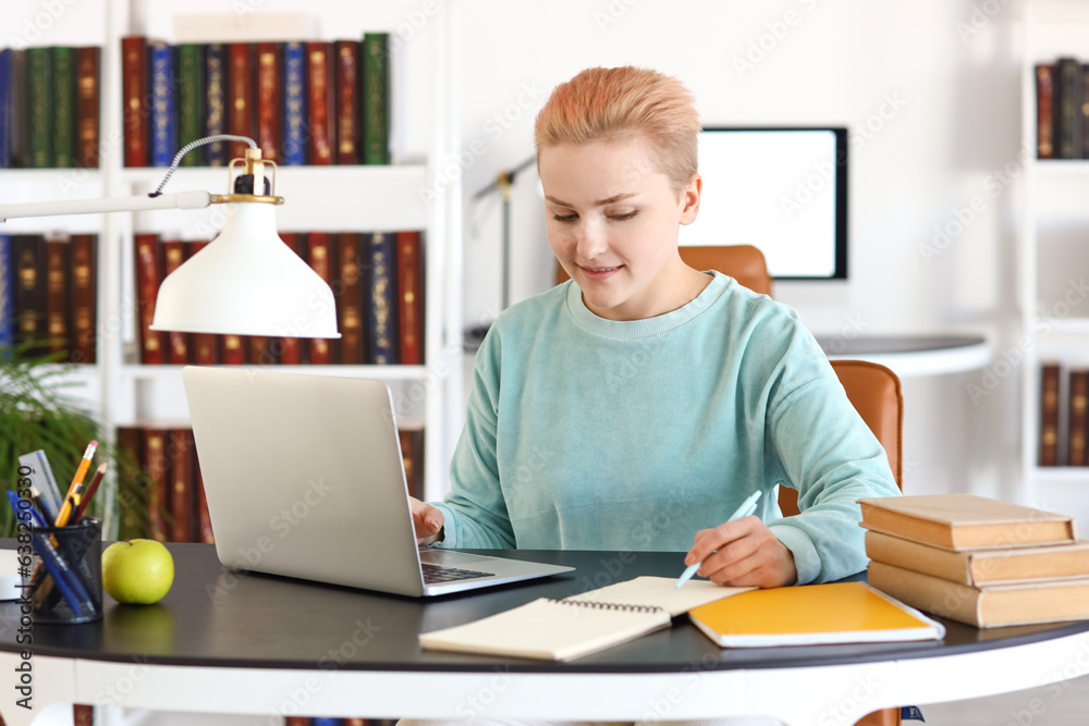 Female student studying at table in library