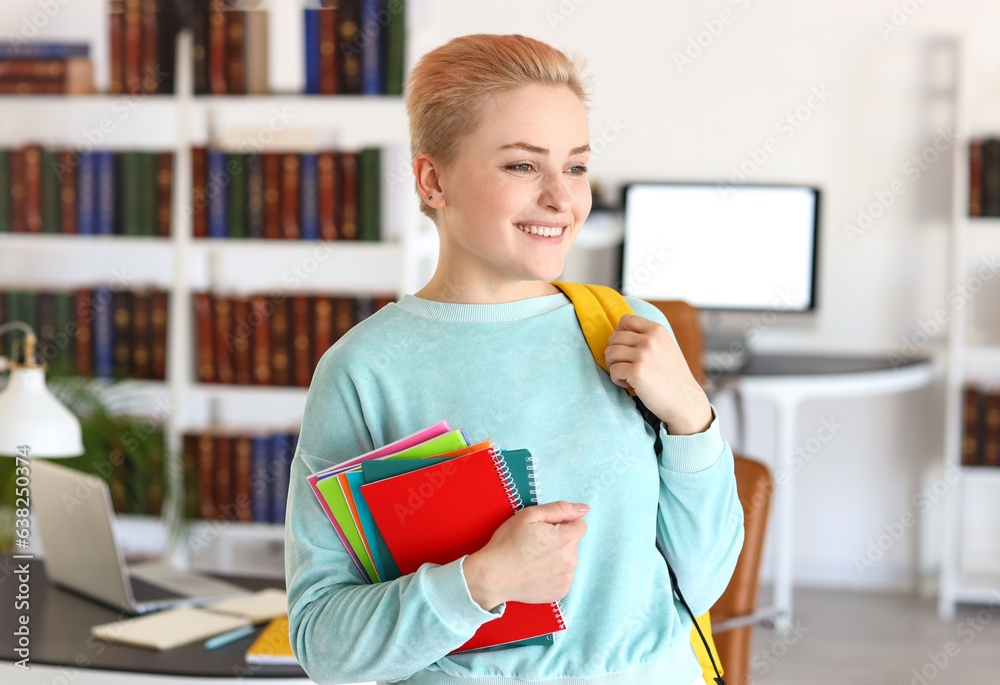 Female student with notebooks in library