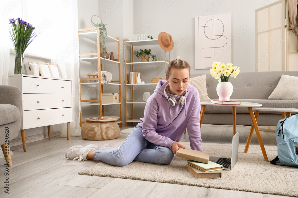 Female student with books and laptop at home