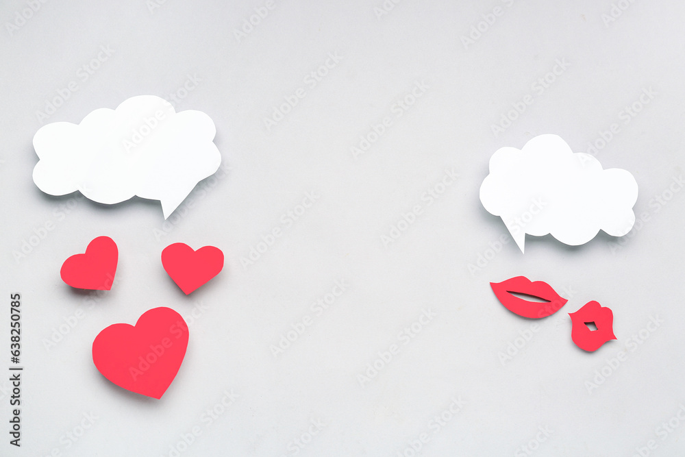 Paper lips and hearts with blank speech bubbles on grey background